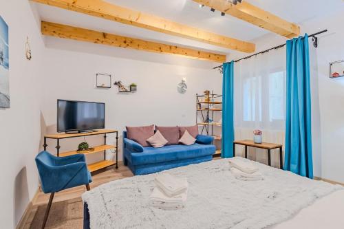 una camera da letto con un letto blu e un divano di Arctic Apartment a Braşov