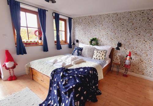 ein Schlafzimmer mit einem großen Bett, blauen Vorhängen und Weihnachtsdekoration. in der Unterkunft Chillinn Bikavér Cottage Eger in Eger