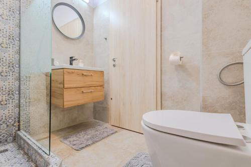 e bagno con servizi igienici e doccia con specchio. di Arctic Apartment a Braşov