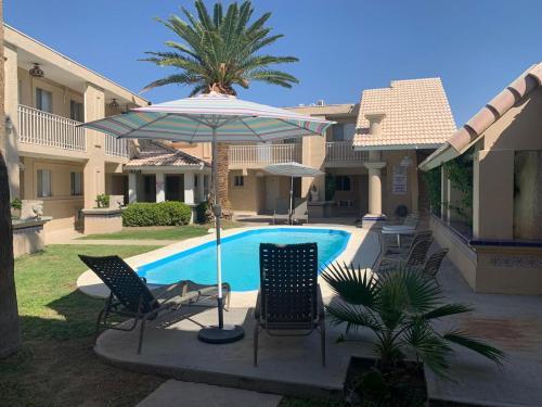a patio with chairs and an umbrella next to a pool at Condomino Maripina in Arena