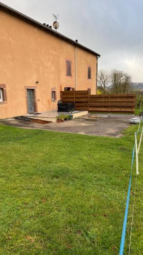 Un edificio con un banco delante de él. en A Cybiclette, en Saint-Étienne-lès-Remiremont