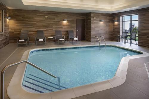 a pool in a hotel room with chairs and tables at Fairfield Inn & Suites by Marriott Lincoln Southeast in Lincoln