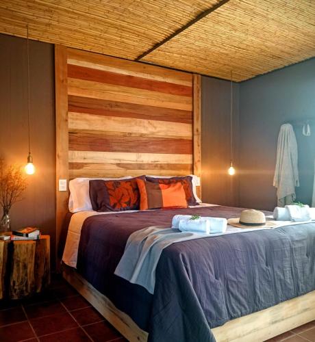 a bedroom with a large bed with a wooden headboard at Brasa Loft de Campo in Colonia Las Rosas
