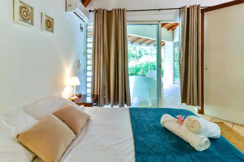a bedroom with a bed with towels on it at Blue Horizon - La Villa Sora - Pool - Sea view in Punaauia