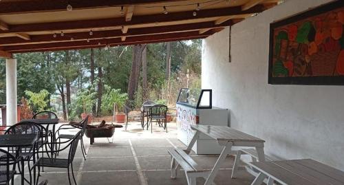 a patio with tables and chairs and a painting on the wall at CABAÑAS DE LAS MARIPOSAS in Valle de Bravo