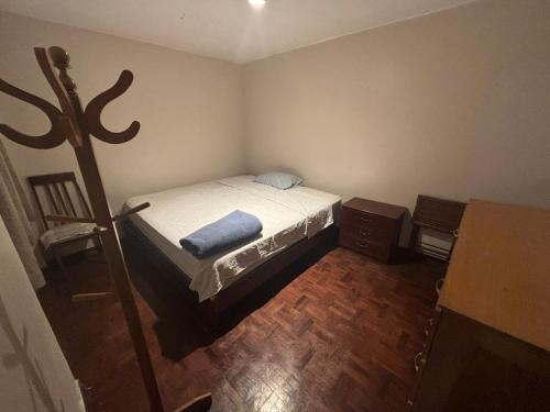 a small bedroom with a bed and a wooden floor at Hostel Wayra Wasi in Lima