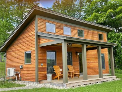 a tiny house with a wrap around porch at Fantastic Vacation Rental on an Authentic Farm in Hartland, Vermont in Sheddsville