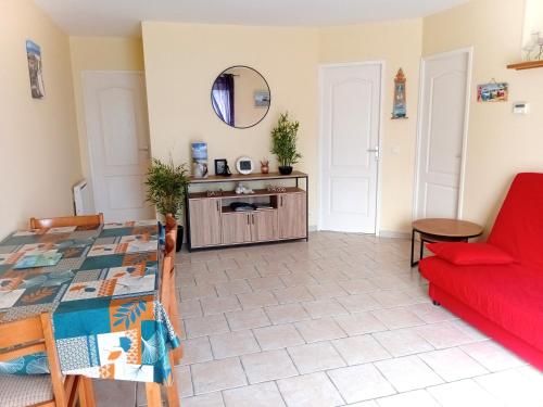 een woonkamer met een rode bank en een tafel bij Logement Soulac sur mer in Soulac-sur-Mer