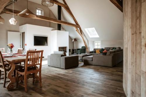 an open living room with a table and chairs at Gîte du jardinier in Ittre