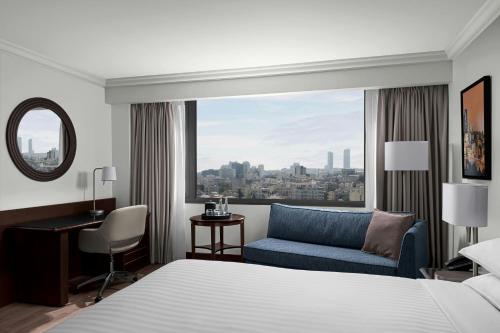a bedroom with a bed and a chair and a window at Amman Marriott Hotel in Amman