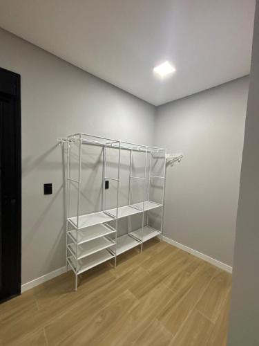 a empty room with a book shelf in it at Tua Casa no Rosa in Imbituba