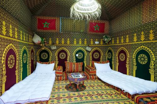 a room with two beds and chairs and a chandelier at Authentic Berber Studio in Benguerir