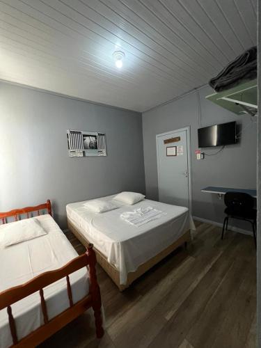 a bedroom with two beds and a desk in it at Hotel Imperial in Toledo