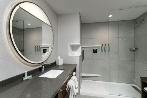 a bathroom with a shower and a sink and a mirror at Courtyard Lewiston in Lewiston