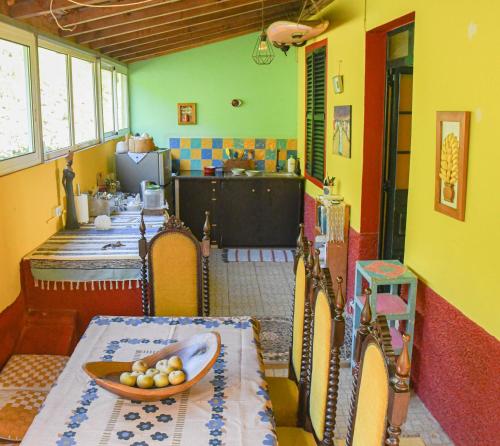 Una cocina con una mesa con un bol de fruta encima. en La Maison ZiaZen, en Porto da Cruz