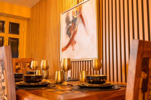 a table with plates and bowls on it with a painting at Spa Cottage - Hot Tub, Cold Pod & Sauna in Morecambe