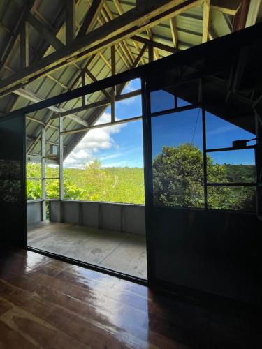 ein leeres Zimmer mit einem großen Glasfenster in der Unterkunft Siquijor Hilltop House Near Cambugahay Falls in Lazi