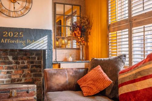 a living room with a couch and a clock at Spa Cottage - Hot Tub, Cold Pod & Sauna in Morecambe