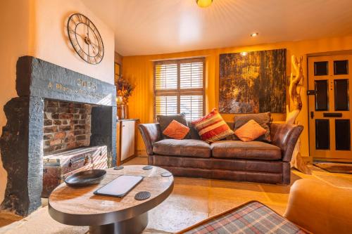 a living room with a couch and a fireplace at Spa Cottage - Hot Tub, Cold Pod & Sauna in Morecambe
