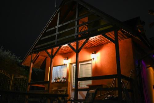a house lit up at night with a porch at Wood House w Kotlinie Kłodzkiej in Kłodzko
