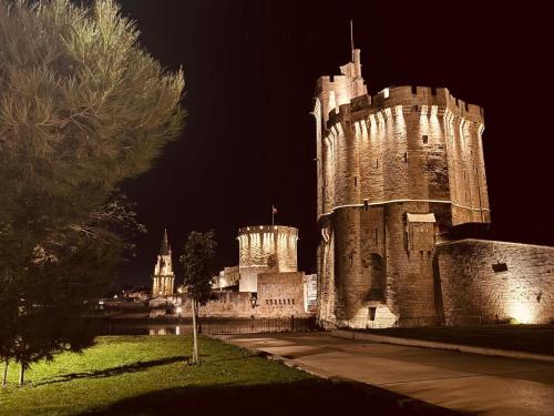 a castle is lit up at night at LoveroomL1TIMISTE TAR in La Rochelle