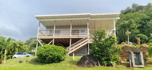 a house on a hill with a car parked in front at Ocean Beach Town View - Infinity Pool in Avarua