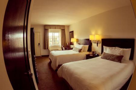 a hotel room with two beds and a window at Barrokas Inn in Piedras Negras