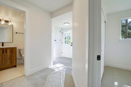 a hallway with white walls and a bathroom with a toilet at The Enchanted Summit in Cripple Creek