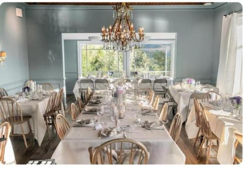 a dining room with white tables and chairs and a chandelier at Rent your own Boutiqe hotel in Skammestein
