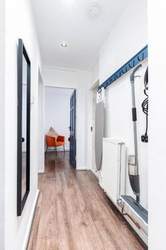 a white room with a hallway with wood floors at The Cozy Corner near NEC Birmingham Airport Entire Apartment Work Desk in Kingshurst