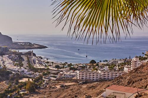 a view of a city with the ocean and buildings at CASA TONINO in Mogán