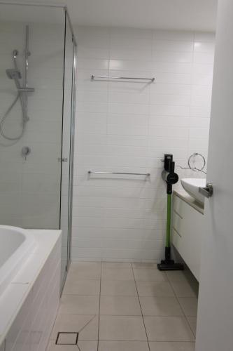 ゴールドコーストにあるキラ サーフ アパートメンツのシャワーと洗面台を備えた白いバスルーム