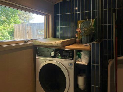 a washing machine in a bathroom with a window at Wonderful Family House At The West Coast in Løkken