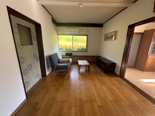 un salon avec une chaise et une table dans l'établissement Cottage Kirihata, à Tanabe