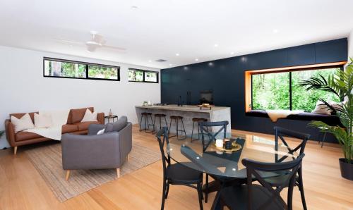 ein Wohnzimmer mit Tisch und Stühlen in der Unterkunft Daydream Cottage Beachside Luxury in Lilli Pilli in Surf Beach