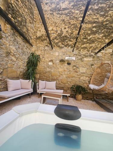 a living room with a couch and chairs and a brick wall at Chambre d'hôtes Gard in Meynes