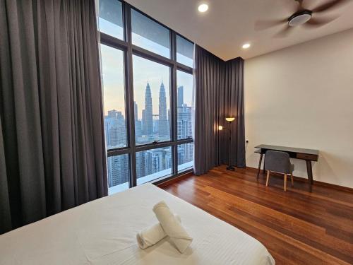 a bedroom with a bed and a desk and a large window at Panorama luxury Suites At TM Persiaran Stonor KLCC in Kuala Lumpur