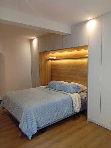 a bedroom with a large bed with a wooden headboard at Casa Larrea in Cuenca