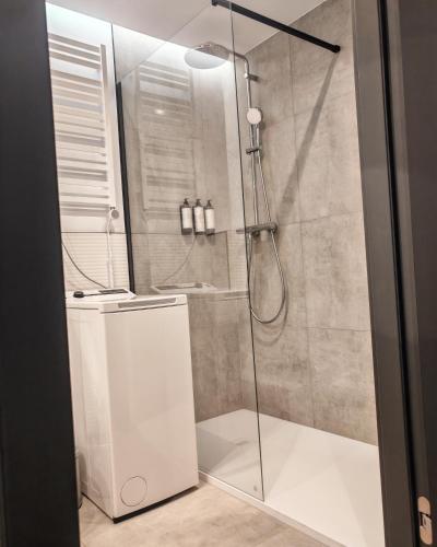 a shower with a glass door in a bathroom at Baltic Jet Silver Sea in Ustronie Morskie