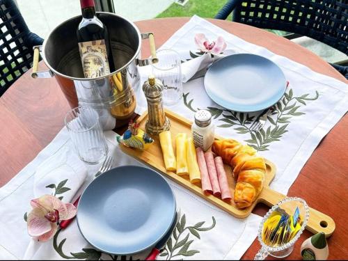 a table with a plate of food and a bottle of wine at Luxuoso e sofisticado Beach Class Summer by HM in Porto De Galinhas