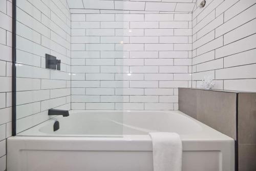 a white bathroom with a bath tub with a towel at 3 Bedroom -walk To The Falls in Niagara Falls