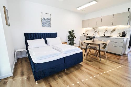 a bedroom with a bed and a table and a kitchen at Green Alpine Nest in Komenda