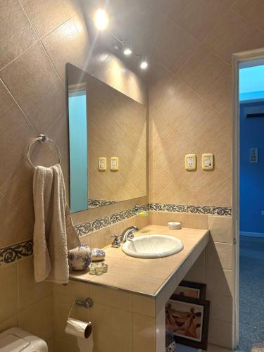 a bathroom with a sink and a large mirror at Residencia La Serena in Bernal