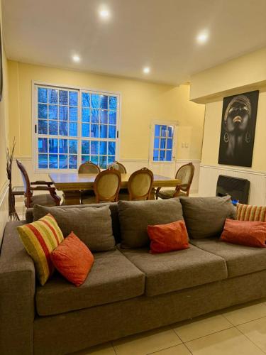 een woonkamer met een bank met kleurrijke kussens bij Residencia La Serena in Bernal