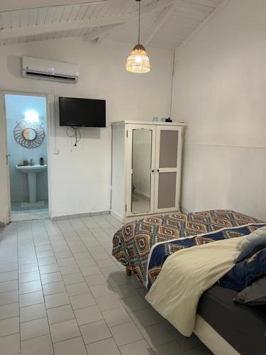 a bedroom with a bed and a tv on the wall at Logement à trois rivières à 5min de l embarcadère in Trois-Rivières