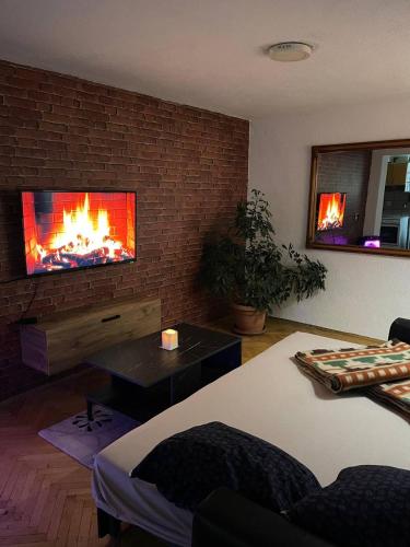 a living room with a fireplace with a tv on a brick wall at TRUTH Apartment Veles in Veles