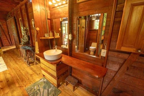 baño con lavabo en una habitación con paredes de madera en Utopia Bluff Beach Off Grid Jungle Retreat By The Sea, en Bocas Town