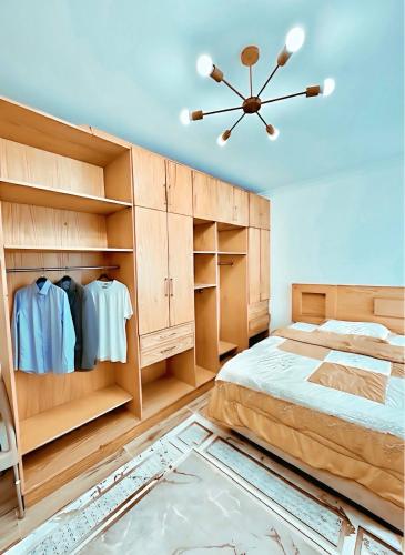 a bedroom with a large bed and wooden cabinets at Stylish Flat at Jannah Compound Sheikh Zayed in Sheikh Zayed