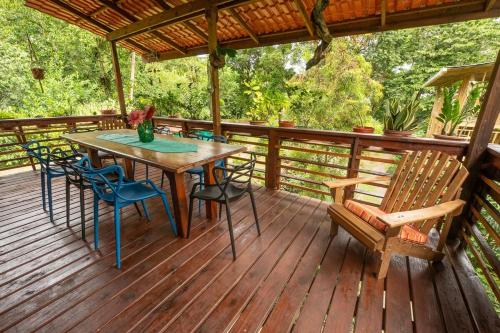 Una terraza de madera con una mesa y sillas. en Utopia Bluff Beach Off Grid Jungle Retreat By The Sea, en Bocas Town
