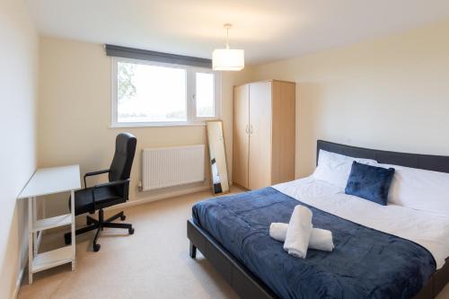 a bedroom with a bed and a desk and a chair at Grand 5BR Home in Market Harborough with Parking in Market Harborough